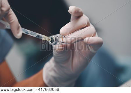 Doctor Using A Syringe Pull Covid-19 Vaccine From Vials Bottles For Can Help Stop Pandemic, Covid-19