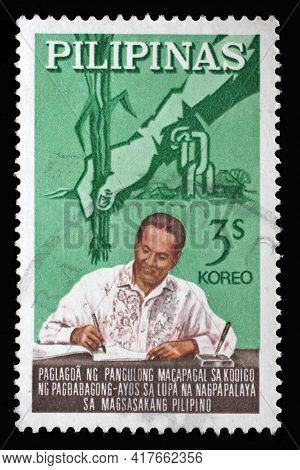 ZAGREB, CROATIA - SEPTEMBER 18, 2014: Stamp issued in the Philippines shows President Macapagal Signing Code, Series: State Reform, circa 1964