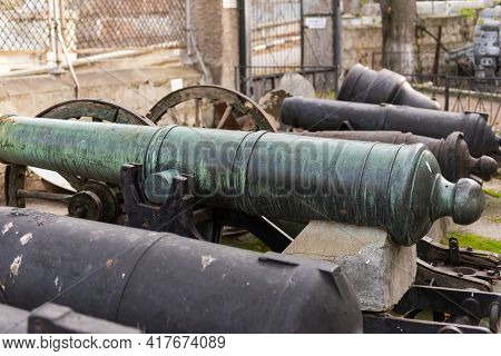 An Old Ship's Cannon. Weapons On A Pedestal At A Historic Building In Sevastopol.
