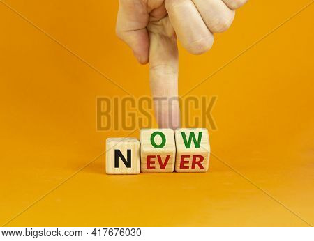 Now Or Never Symbol. Businessman Turns Wooden Cubes And Changes The Word 'never' To 'now' Or Vice Ve