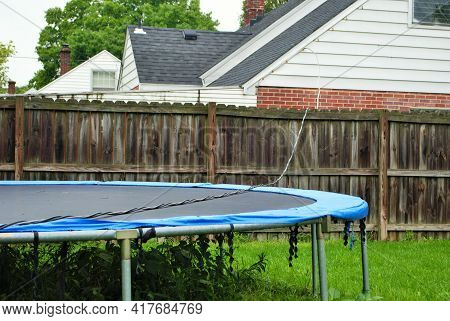 Dangerous Live Downed Power Line Draped Across Fence And Trampoline