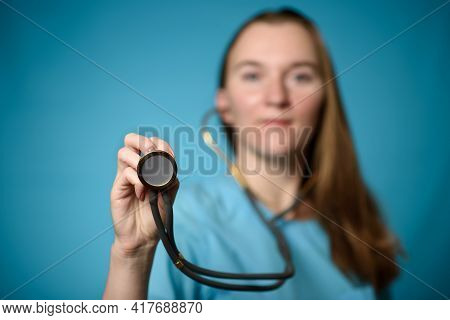 A Doctor On A Blue Background Holds A Stethophonendoscope. Close-up