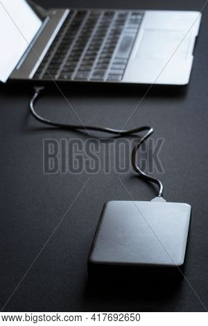 External Peripheral Gadget - 2.5 Hard Drive Connected To Laptop Or Ultrabook. Data Transfer. Dark Ta