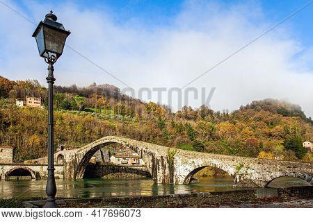 Devil's Bridge over the Sercchio River. Cold windy winter day. Travel to fabulous Italy. Picturesque stone bridge built a thousand years ago. 