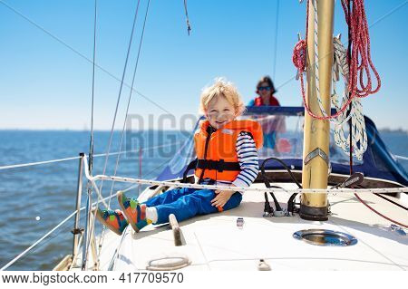 Kids Sail On Yacht In Sea. Child Sailing On Boat. Little Boy In Safe Life Jackets Travel On Ocean Sh