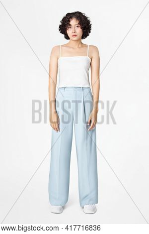 Woman in white tank top and blue loose pants minimal fashion
