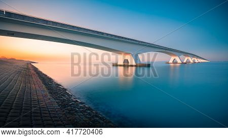A Breathtaking View Of A Bridge Over A Peaceful River Captured In Zeelandbridge, Netherlands