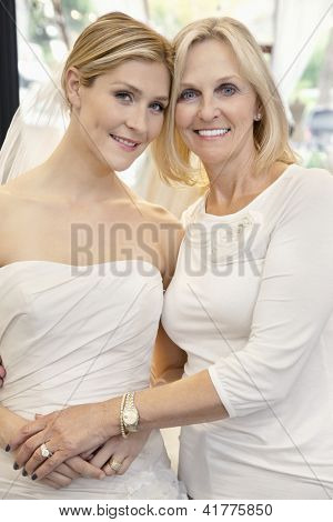 Ritratto di una madre con la figlia, vestita da sposa in negozio da sposa