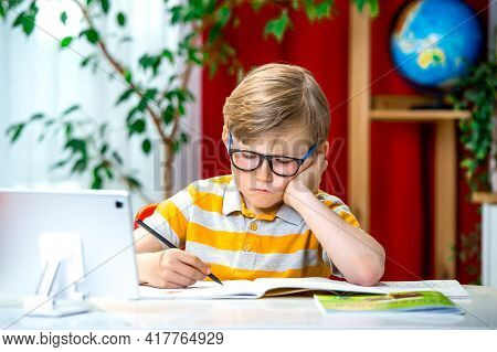 Tired School Guy In Glasses Rubbing His Eyes. Stressed Tired From Studying In Front Of Tablet Laptop