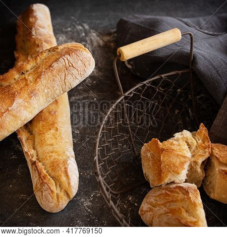 Fresh Crispy French Baguette On Black Background. Atmosphäric Food Photography With Space For Text.