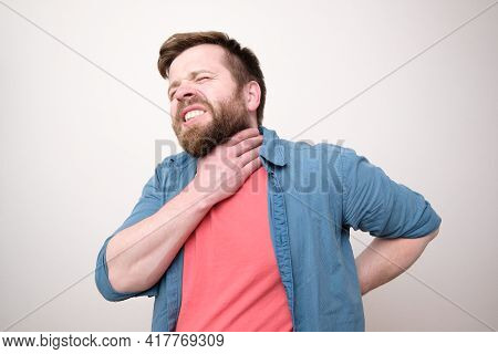 Man Suffers, He Has A Sore Throat And Back, He Holds On To The Inflamed Parts Of Body With Hands, Ba