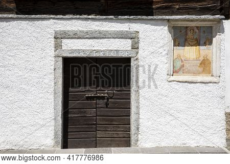 Canza (vco), Italy - June 21, 2020: An Old Wooden Door And A Religius Paint At Canza Village, Formaz