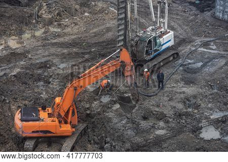 Wheel Loader Excavator With Backhoe Unloading Sand At Eathmoving Works In Construction Site.