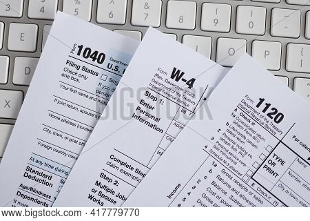 Tax Form Documents Lying On Computer Keyboard Closeup