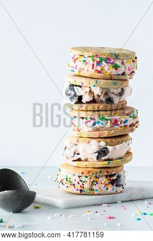 Close Up Of A Stack Of Homemade Black Cherry Ice Cream Sandwiches With Sprinkles And An Ice Cream Sc