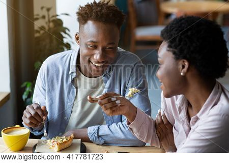 Romantic Valentines Dinner. Loving Black Couple Eating Cake Together At Cafe, Spending Cozy Moments 