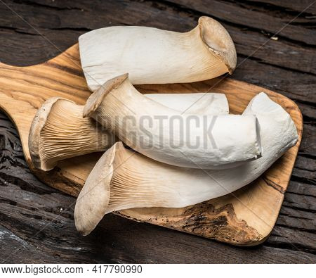 King oyster mushrooms on the wooden background.