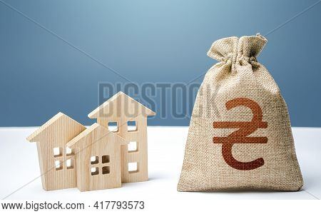 Ukraine Hryvnia Money Bag And Residential Buildings. City Municipal Budget. Mortgage Loan. Purchase 