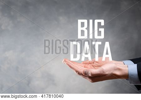 Businessman In A Suit On A Dark Background Holds The Inscription Big Data. Storage Network Online Se