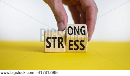 Strong Stress Symbol. Businessman Turns Wooden Cubes With Words 'strong Stress'. Beautiful Yellow Ta
