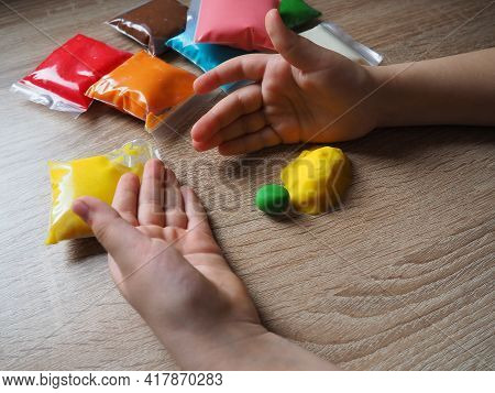 Classes With Plasticine. Children's Hands Crumple Soft Plasticine. Packages With Plasticine Are On T