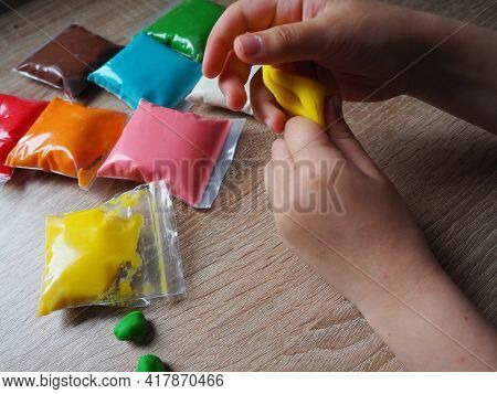 Classes With Plasticine. Children's Hands Crumple Soft Plasticine. Packages With Plasticine Are On T