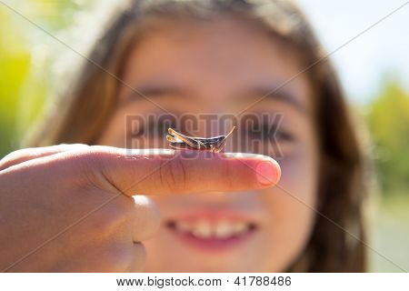 kid hand holding grasshopper bug macro detail