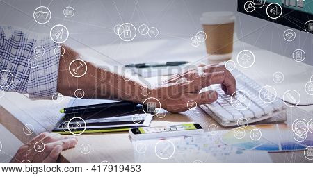 Composition of network of connections with digital icons over man typing on computer keyboard. global technology and digital interface concept digitally generated image.