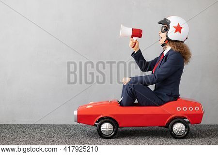 Successfull Businesswoman Driving Toy Car Outdoor
