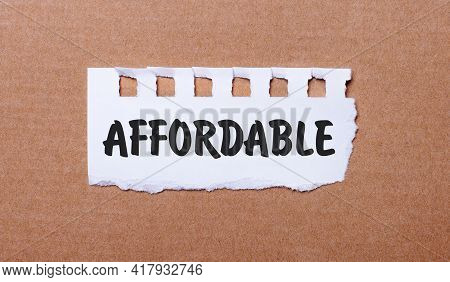 On A Brown Background, White Paper With The Inscription Affordable