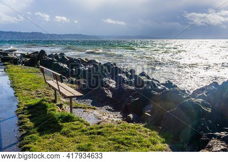 Back Rocks Lin The Shore On A Windy Day At Satlwater State Park In Washington State.