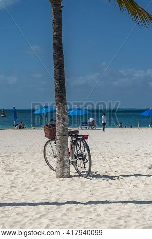 Bcycle Leaning On Palm Tree At A White Sandy Beach On Isla Mujeres. Cancun, Mexico, Vertical