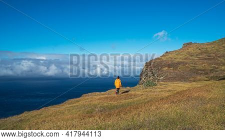 Young Female Dressed In Orange Waterproof Jacket Walking By The Mountain Above The Cloud Route On Ma