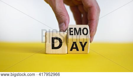 Demo Day Symbol. Businessman Turns A Cube And Changes The Word 'day' To 'demo'. Beautiful Yellow Tab