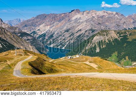 Cycling Trail In The Bike Park In Livigno, With The View On The Lake Livigno In The Middle Of The It