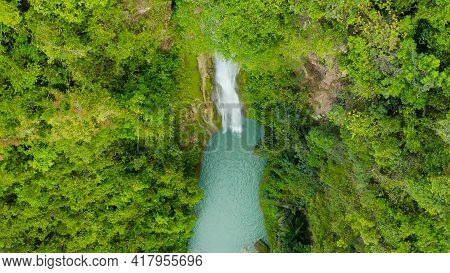 Aerial Top View Jungle Waterfall In A Tropical Forest Surrounded By Green Vegetation. Mantayupan Fal