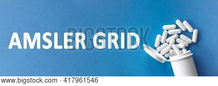 The Word Amsler Grid Is Written Near Pills On A Light Blue Background. Medical, Health And Happiness