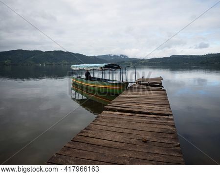 Boat Passenger Ship Vessel Waiting At Idyllic Amazon Rainforest Jungle River Lake Wooden Jetty Dock 