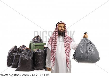 Saudi arab man throwing a plastic waste bag in a bin isolated on white background