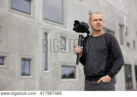 Portrait Of Professional Male Videographer Posing With Dslr Camera On 3-axis Gimbal Stabilizer, Copy