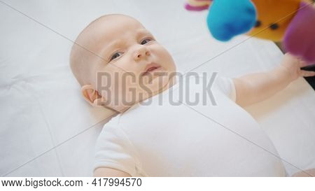 Photo Of Unhappy Bratty Four Month Girl With Baby Mobile
