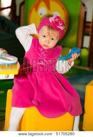 Happy Child Girl Talking On The Phone On Playground  The Concept Of Childhood And Holiday
