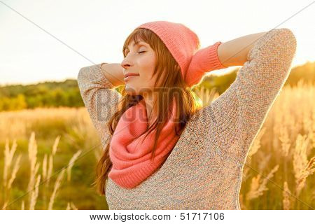 female in sunset field colder season