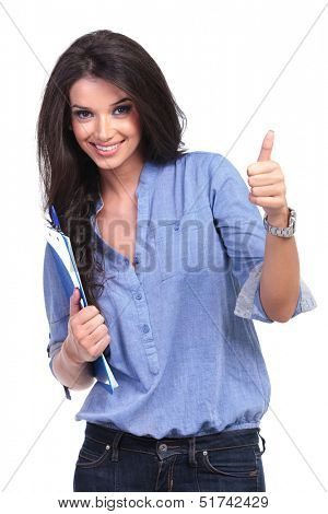 young casual woman holding a clipboard and showing the thumb up gesture while smiling. on white background