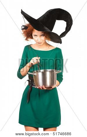 Charming red-haired witch brews a witch's brew. Halloween. Isolated over white. 