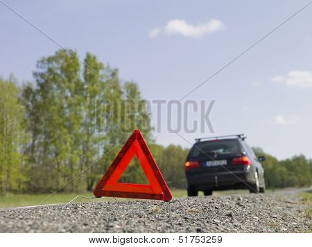Warning triangle in front of a car breakdown