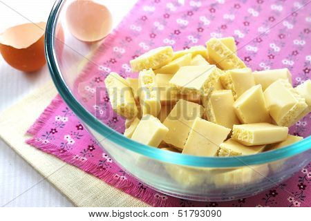 Bar Of White Chocolate Broken Into Pieces In A Glass Bowl