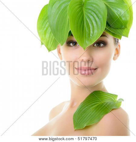 beautiful yoiung cheerful woman with green leaves near her face, over white background