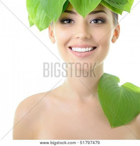 beautiful yoiung cheerful woman with green leaves near her face, over white background