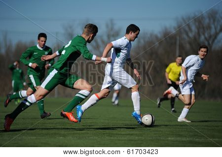 KAPOSVAR, HUNGARY - MARCH 1: Unidentified players in action at the Hungarian National Championship U17 game between Kaposvar (white) vs Ferencvaros (green) March 1, 2014 in Kaposvar, Hungary.